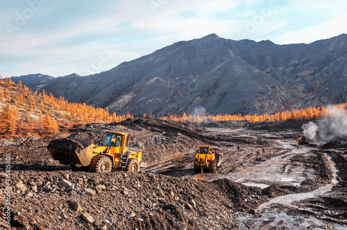 Wheel loaders and bulldozers in operation in an industrial mountainous area