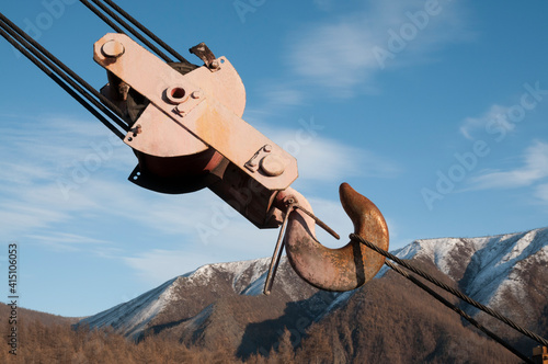 Hook from a mobile crane against the backdrop of mountain snow-capped peaks