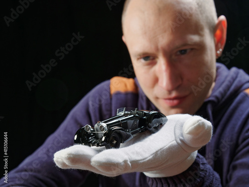 GOMEL, BELARUS - February 16, 2021: portrait of a collector of retro car models on a black background photo