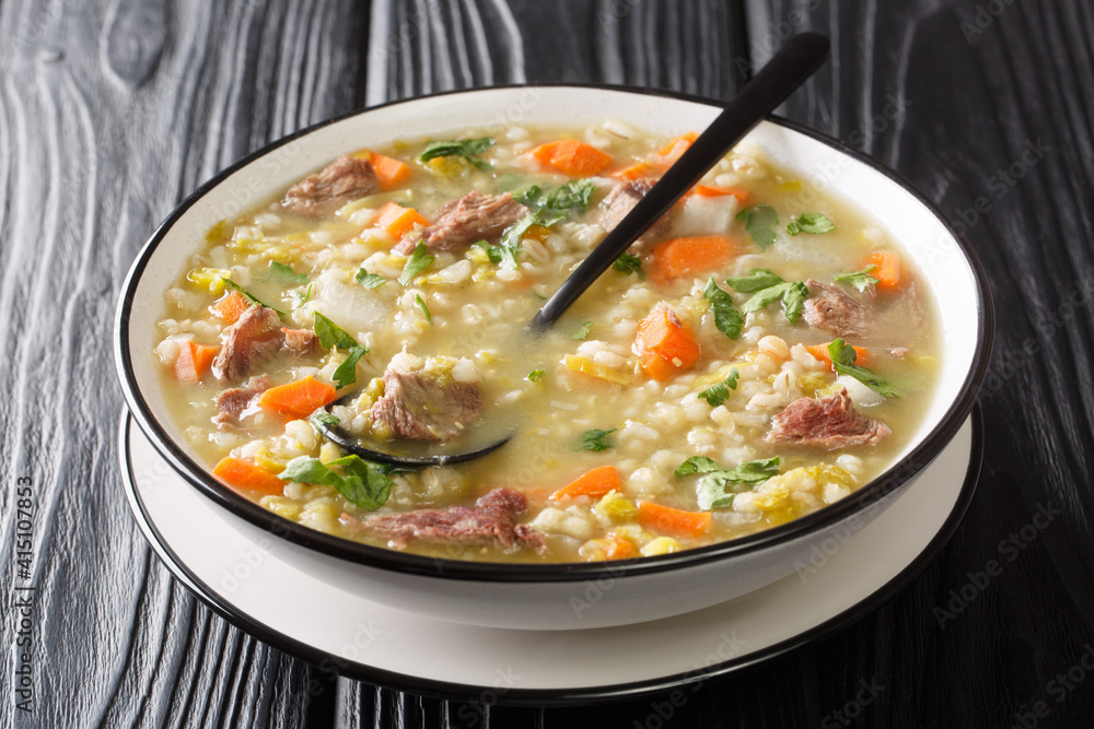 Scotch broth is a traditional hearty Scottish soup  closeup in the plate on the table. Horizontal