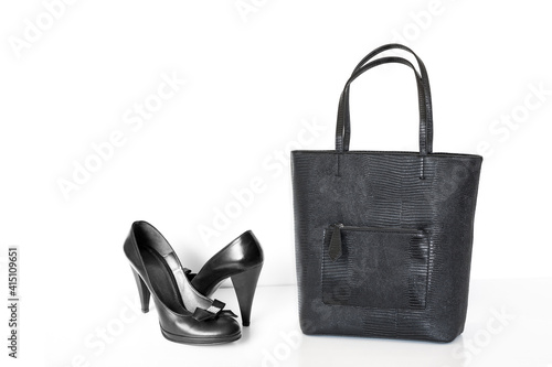 Pair of classy black ladies shoes decorated with bow and brooch and large shopper handbag