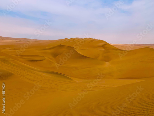 Desert sand dunes  yellow sandy waves  arid sunny climate  rippled hills in Sahara  incredible extreme terrain.