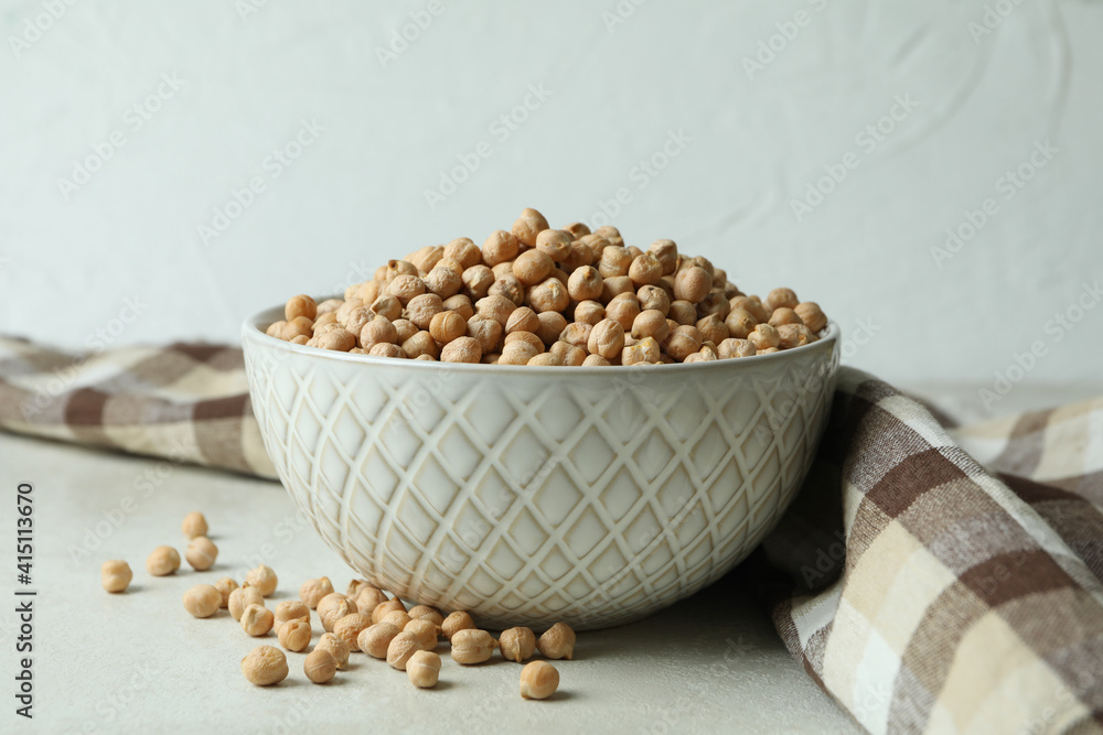 Bowl with chickpea on white textured table with kitchen towel Bowl with chickpea on white textured table with kitchen towel