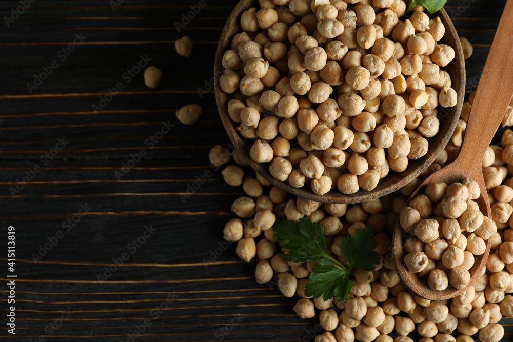 Bowl and spoon with chickpea on wooden table Bowl and spoon with chickpea on wooden table