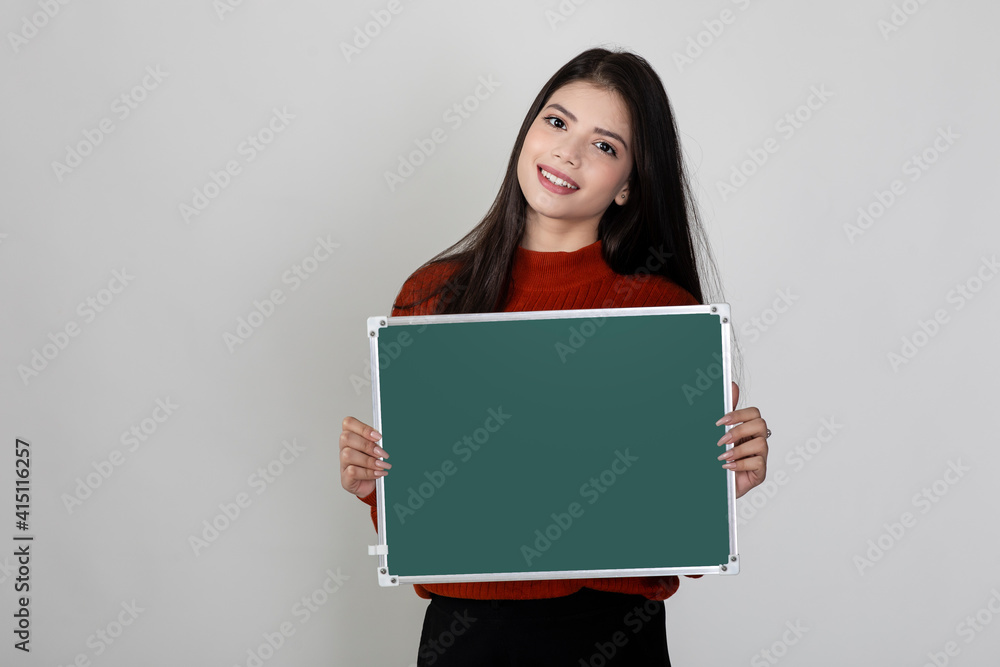 Happy young pretty female smiling at camera holding blank chalkboard, showing something interesting and exciting on slate with copy space for text. Happy young pretty female smiling at camera holding blank chalkboard, showing something interesting and exciting on slate with copy space for text.