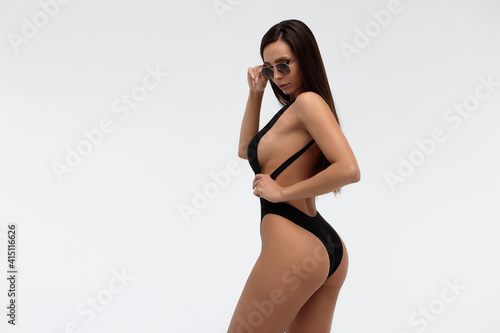 Sexy slim model in stylish black swimsuit
