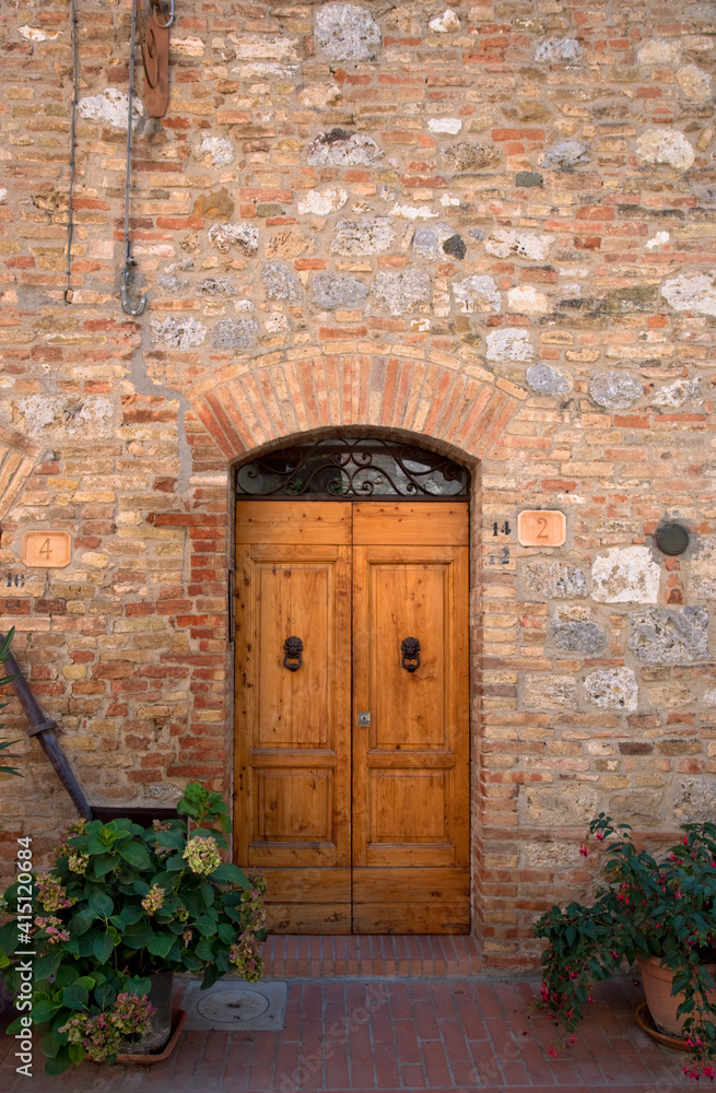 Sienna, Tuscany, Italy - Wooden doors in a brick and stone building.