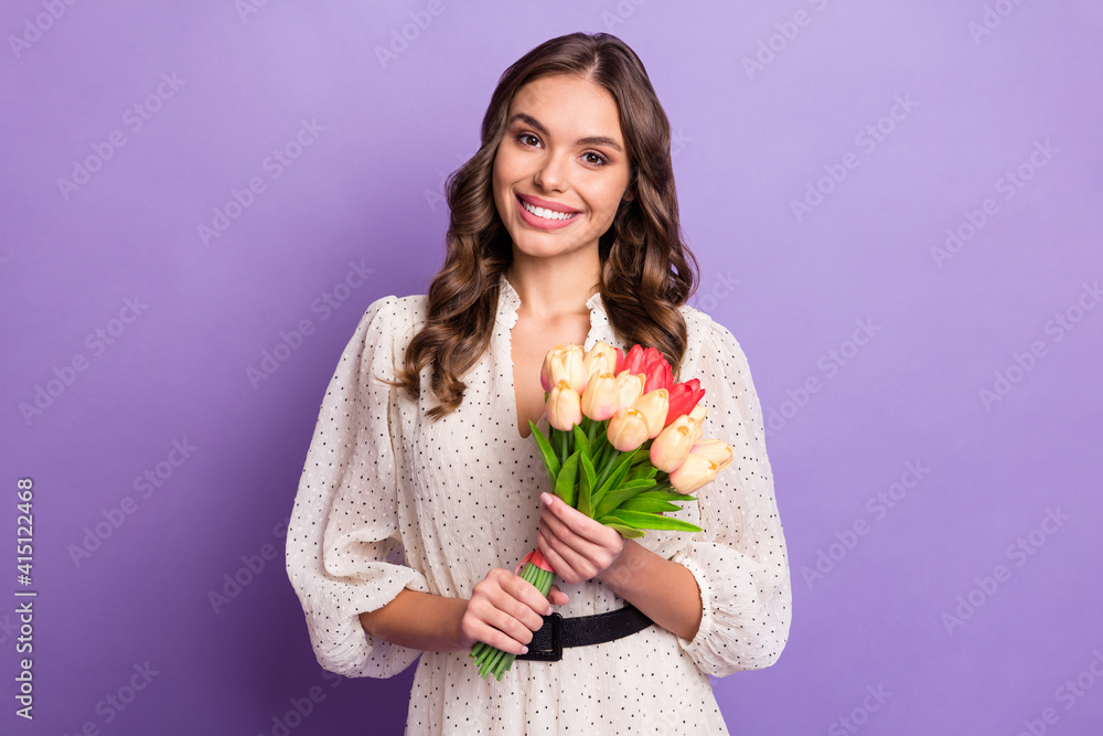 Photo portrait of happy girl keeping flowers bouquet on 8 march wearing dress isolated on pastel violet color background Photo portrait of happy girl keeping flowers bouquet on 8 march wearing dress isolated on pastel violet color background