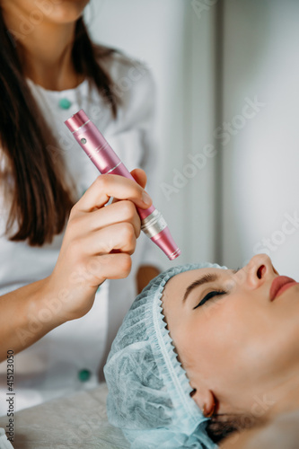 Beautiful woman getting facial peeling procedure in beauty clinic, close-up portrait. A girl with perfect skin on a non-surgical facelift. Rejuvenating facial treatment.