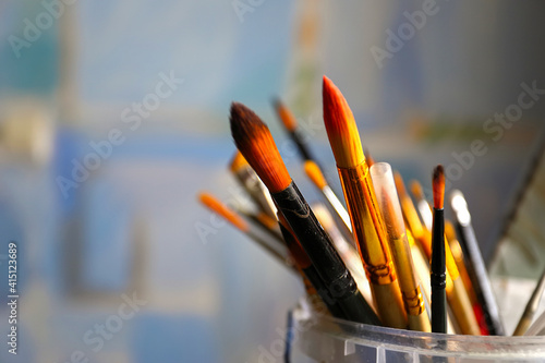 Art studio class painting brushes close up on blue abstract background. Brushes. Artist's workshop, artist's tools. Specially blurred.