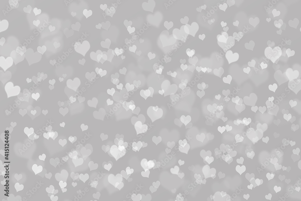 Bokeh background with heart pattern on grey background .