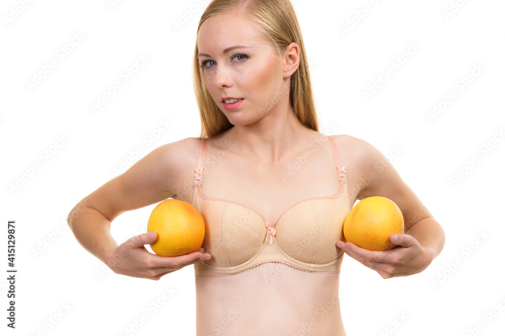 Woman small boobs holds big orange fruits Woman small boobs holds big orange fruits