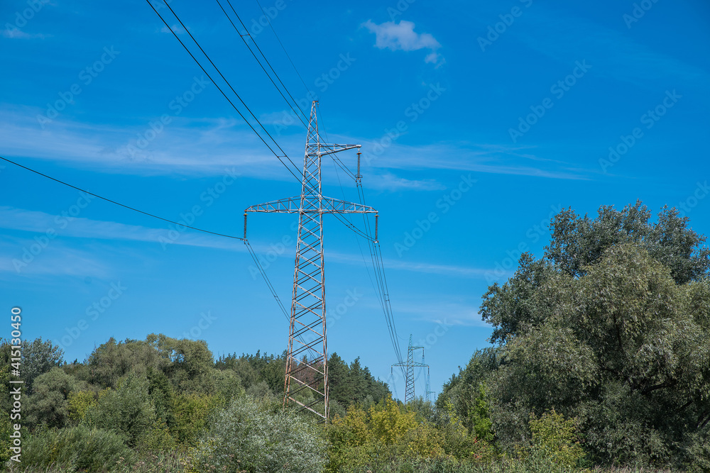 High voltage tower in the forest. Electric Power Transmission Lines over trees