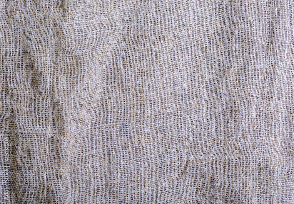 Fototapeta premium The texture of the burlap. Natural aged linen texture with creases and shadows.