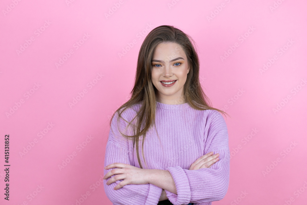 Fototapeta premium Young pretty woman with long hair standing over isolated pink background with a happy face standing and smiling with a confident smile showing teeth with arms crossed
