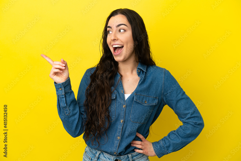 Young caucasian woman isolated on yellow background intending to realizes the solution while lifting a finger up Young caucasian woman isolated on yellow background intending to realizes the solution while lifting a finger up