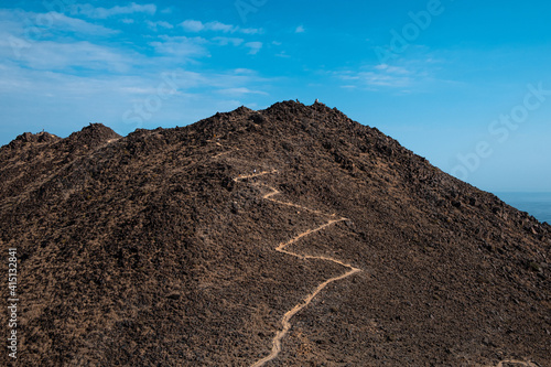 Beautiful view of a hiking trail on the mountain against the blue sky in the United Arab Emirates photo