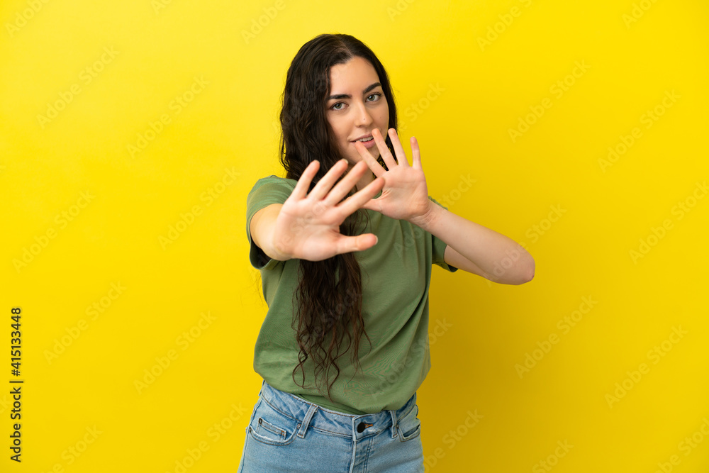 Young caucasian woman isolated on yellow background nervous stretching hands to the front Young caucasian woman isolated on yellow background nervous stretching hands to the front