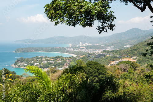 Bird eye view on Phuket island coastline. Panorama of tropical beach. Beautiful turquoise ocean waves with boats and sandy coastline from high view point.