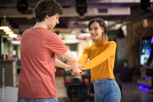 Young couple having fun in bowling alley.