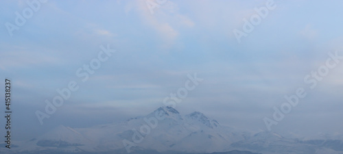 Snowy view of Mount Erciyes in Kayseri, Turkey. Cityscape with mountain and clouds in the evening. © jineps