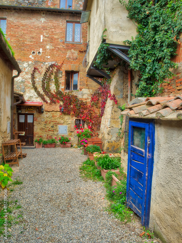 Europe, Italy, Chianti. Back street alleyway with bright blue hand painted do...