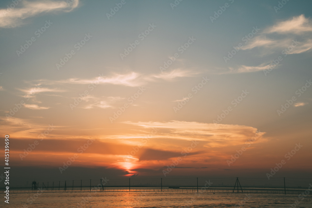 夕焼けの海と電柱