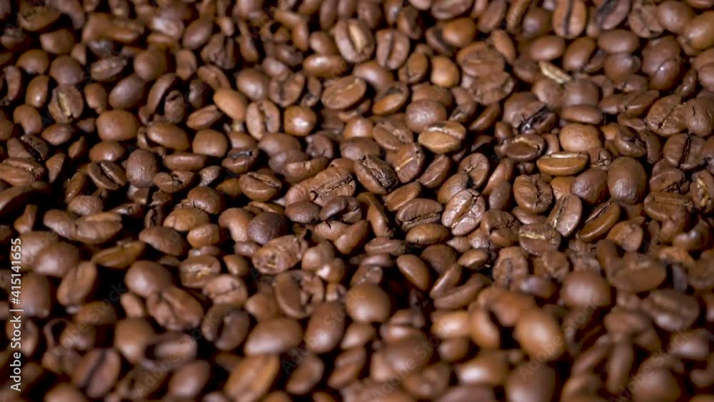 Dark Coffee Grains. Rotating and falling. Coffee beans. Close up of seeds of coffee. Beautiful seeds of coffee. Dark Coffee Grains. Rotating and falling. Coffee beans. Close up of seeds of coffee. Beautiful seeds of coffee.