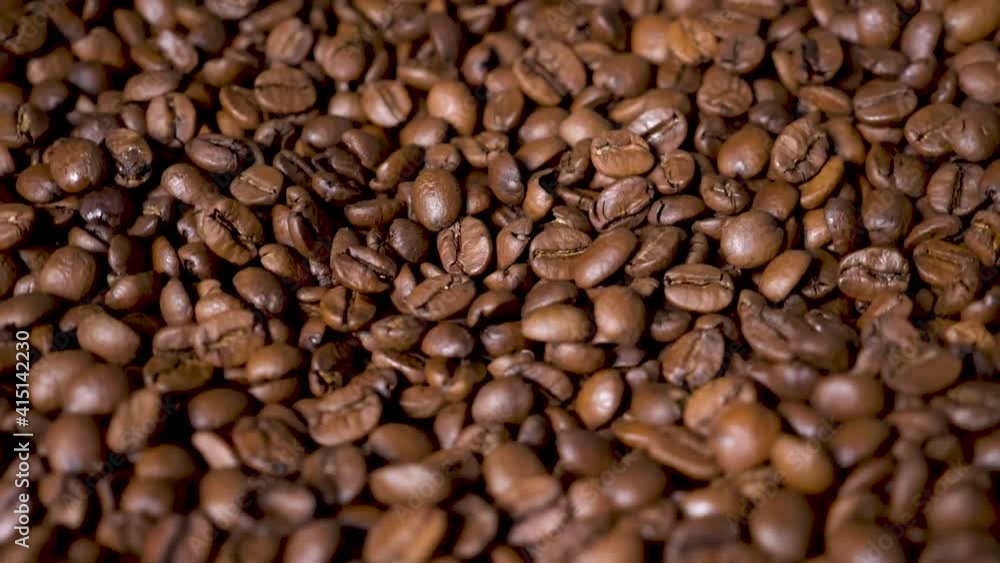 Dark Coffee Grains. Rotating and falling. Coffee beans. Close up of seeds of coffee. Beautiful seeds of coffee. Dark Coffee Grains. Rotating and falling. Coffee beans. Close up of seeds of coffee. Beautiful seeds of coffee.