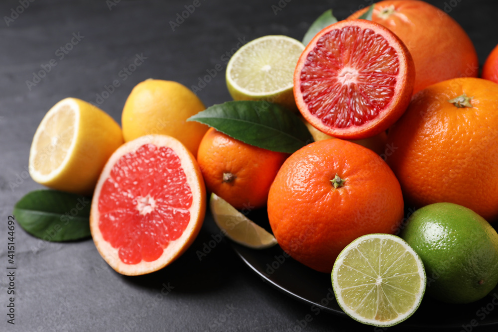 Different citrus fruits on black table, closeup Different citrus fruits on black table, closeup