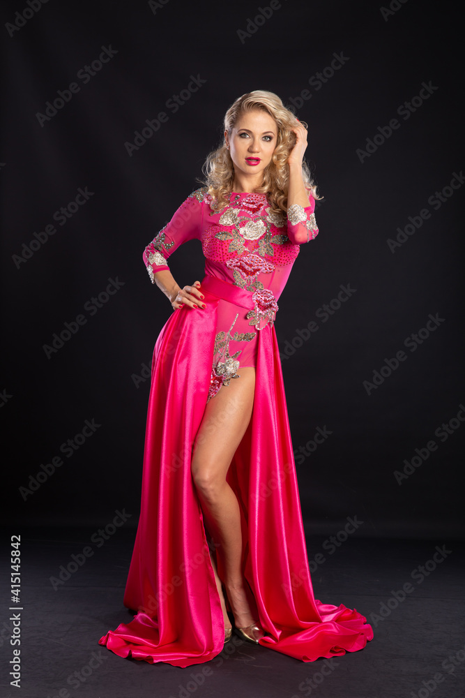 Beautiful blonde in a pink sexy dress on a black background. Beautiful blonde in a pink sexy dress on a black background.