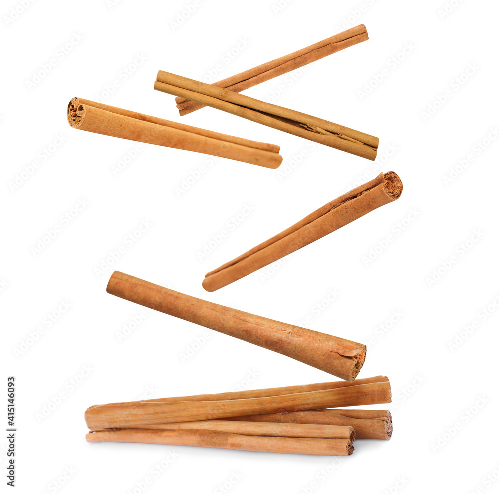 Aromatic cinnamon sticks falling on white background Aromatic cinnamon sticks falling on white background