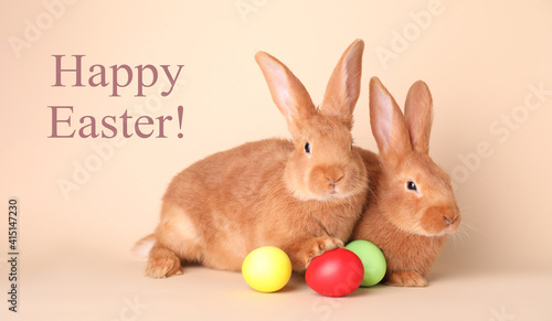 Happy Easter! Cute bunnies and dyed eggs on beige background © New Africa