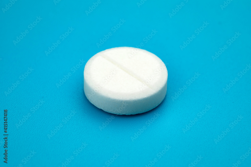White round pill on blue background. Health care concept. White round pill on blue background. Health care concept.