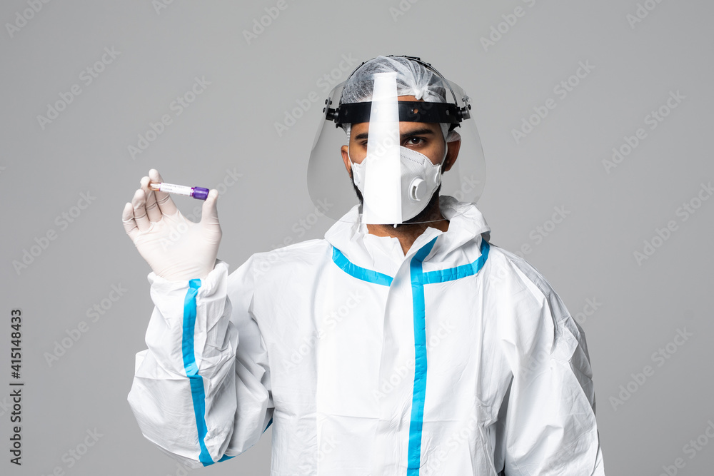 Positive COVID-19 test. Virologist in a medical mask and protective suit holds a test tube with positive blood sample isolated on white background Positive COVID-19 test. Virologist in a medical mask and protective suit holds a test tube with positive blood sample isolated on white background