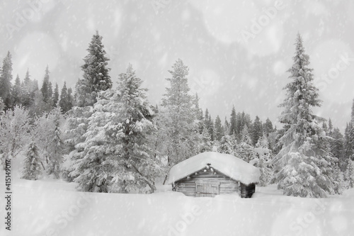 Snowflakes falling on traditional wooden hut in the snow capped forest, Lapland, Finland