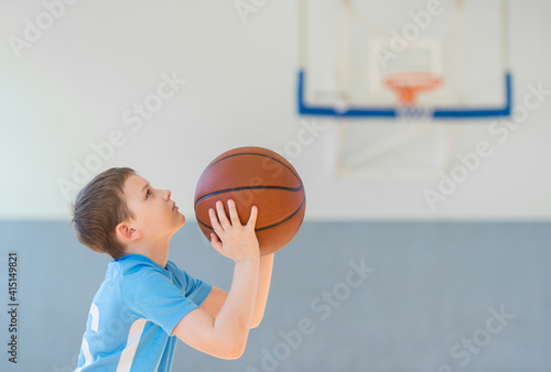 School kid playing basketball in a physical education lesson. Safe back to school during pandemic concept