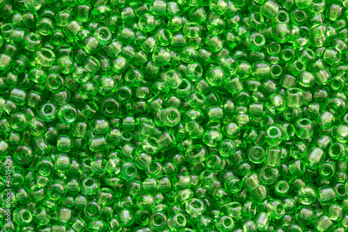 Background texture of green color beads closeup. Seamless beads texture. Hobbies, handmade jewelry, craft. Abstract background