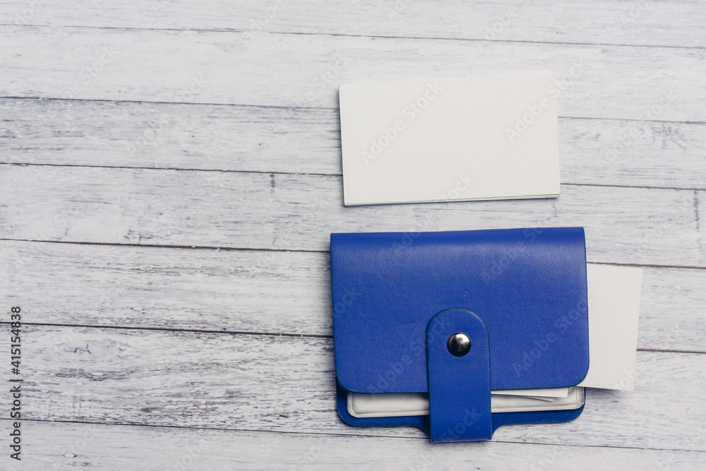 blue business card holder and white letterheads on a wooden table Copy Space blue business card holder and white letterheads on a wooden table Copy Space