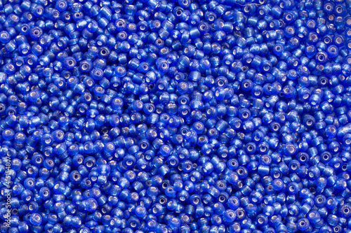 Background texture of Royal blue color beads closeup. Seamless beads texture. Hobbies, handmade jewelry, craft. Abstract background