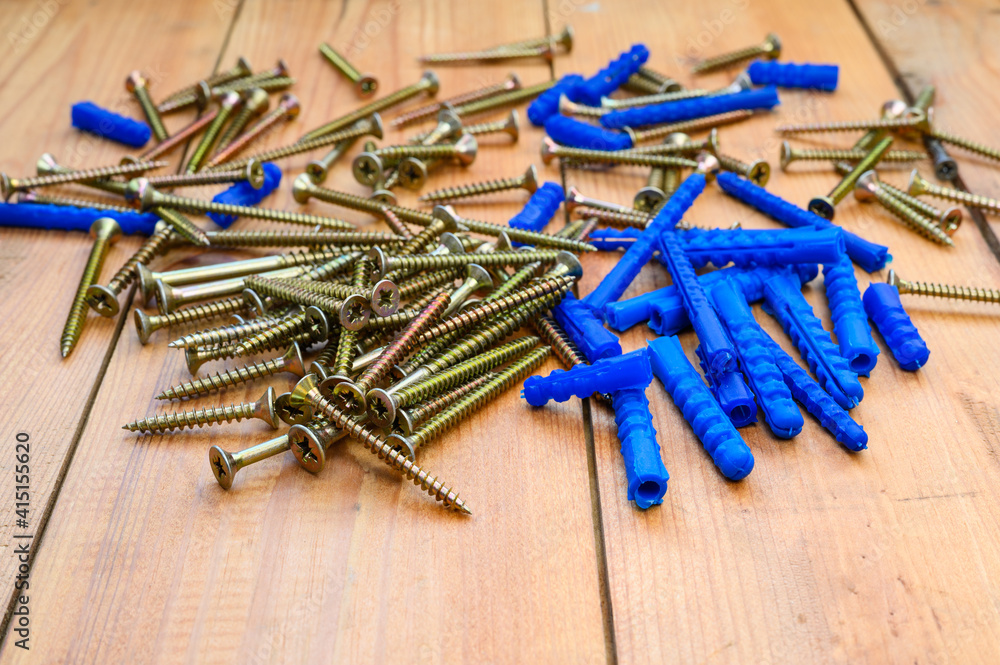 Lots of blue dowels and self-tapping screws cut on a wooden table. Selective focusing in the foreground. Lots of blue dowels and self-tapping screws cut on a wooden table. Selective focusing in the foreground.