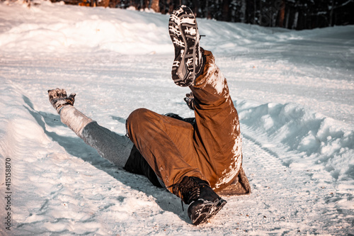 Fényképezés person laying on the ground on his back after he slipped and falled down due to slippery road conditions