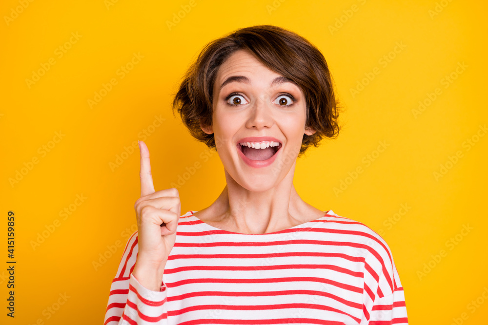 Portrait of young attractive cheerful smiling crazy girl pointing finger copyspace isolated on yellow color background Portrait of young attractive cheerful smiling crazy girl pointing finger copyspace isolated on yellow color background