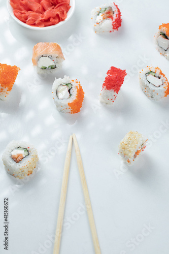 Mini sushi rolls with red caviar and cream cheese served with marinated ginger