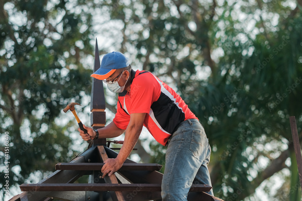 Carpenter making installation of roof structure on a new gazebo construction project Carpenter making installation of roof structure on a new gazebo construction project