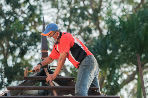 Carpenter making installation of roof structure on a new gazebo construction project