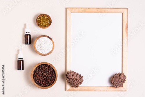 Natural product concept, template for writing text. Pine nuts, oil, extract. White sheet in a frame, top view