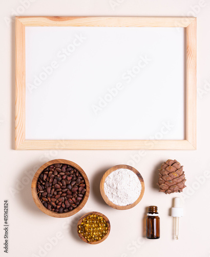Natural product concept, template for writing text. Pine nuts, oil, extract. White sheet in a frame, top view photo