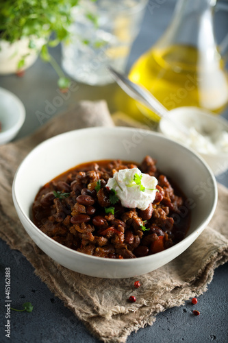 Homemade beef chili con carne with sour cream