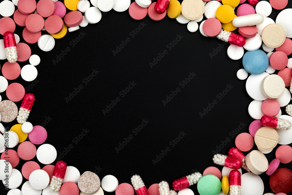 Background of assorted pharmaceutical capsules and medication in different colors.
